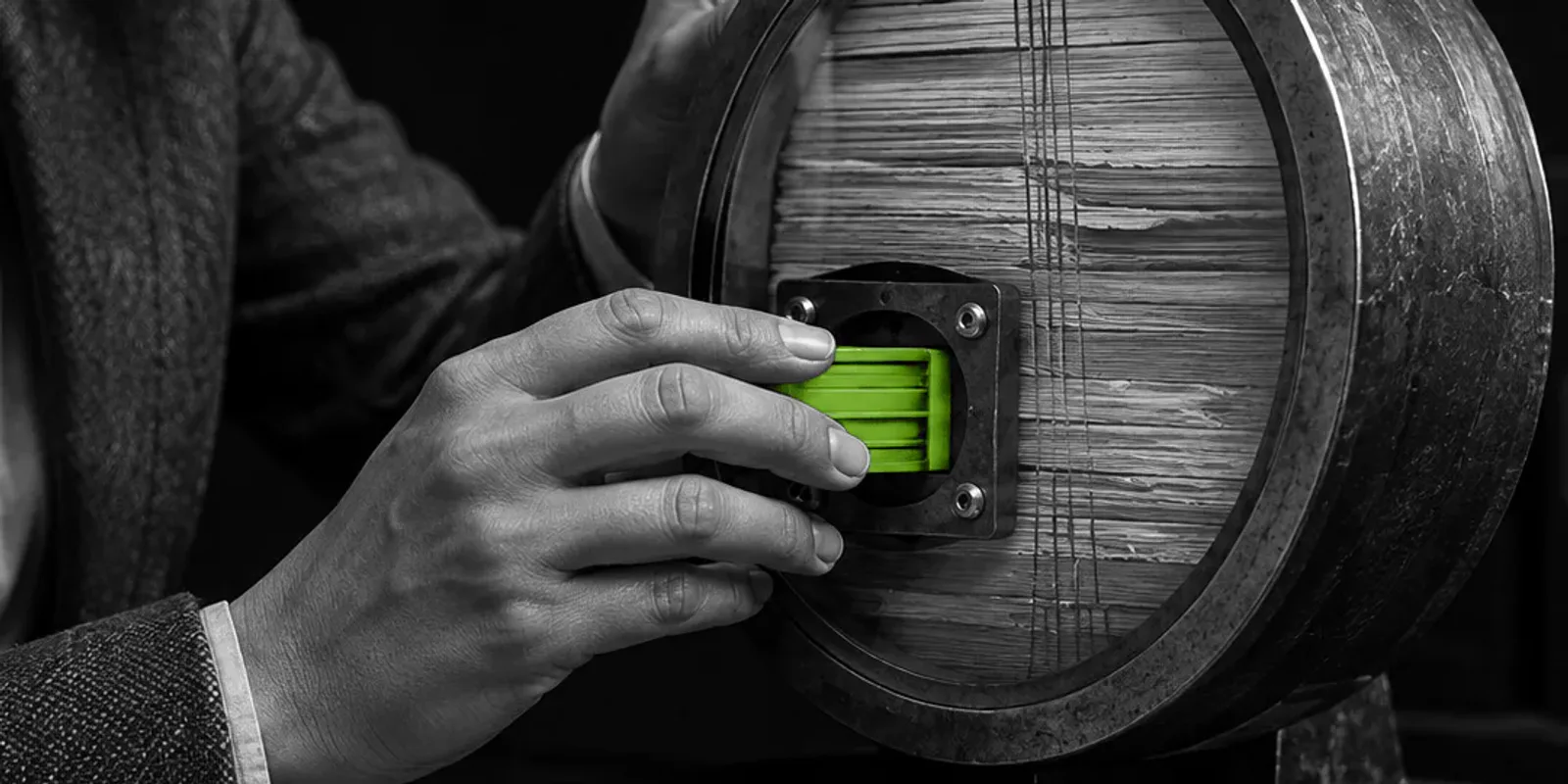 Una profesional jurídica anónima encaja un módulo verde en el núcleo de un mecanismo de metal que comprime capas de archivo en blanco y negro.