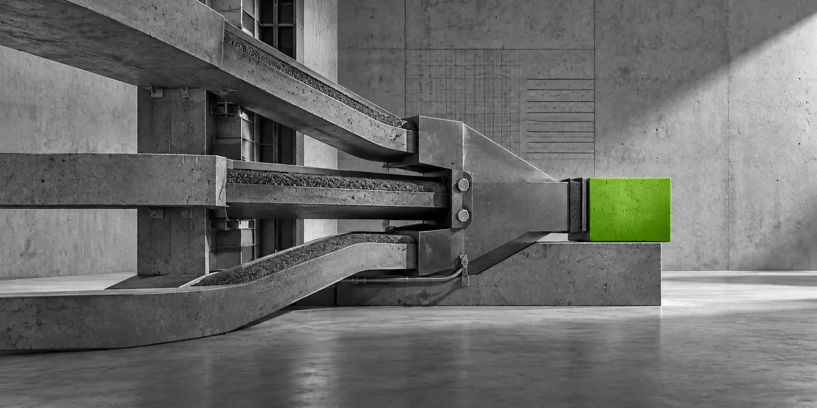 Una estructura de hormigón y metal conduce varios canales grises hacia un único bloque verde compacto.