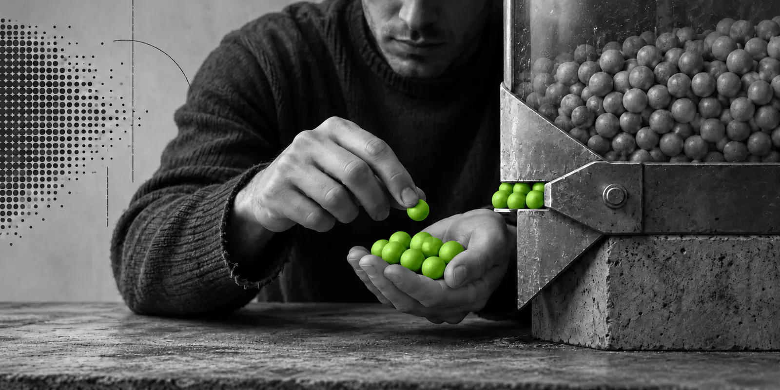 Una persona anónima selecciona unas pocas esferas verdes de una gran tolva gris que limita su salida.